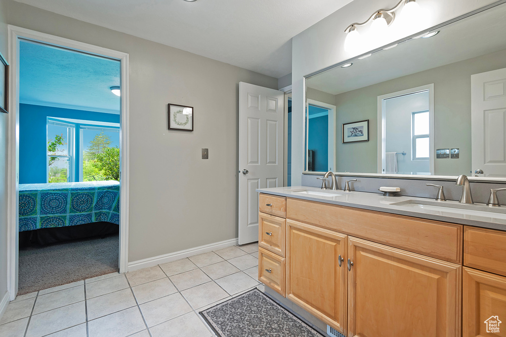 Full bath with tile patterned flooring, baseboards, and double vanity