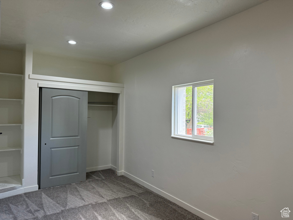 Unfurnished bedroom featuring recessed lighting, carpet flooring, a closet, and baseboards