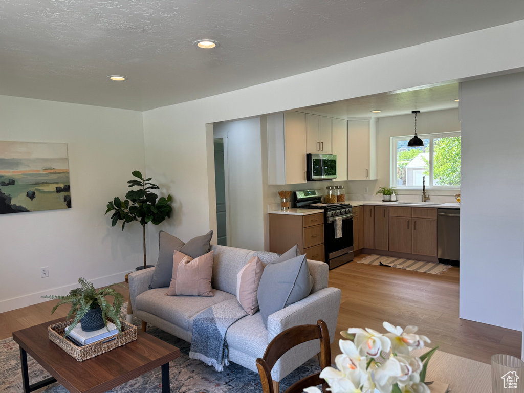 Living room featuring light wood finished floors, recessed lighting, and baseboards