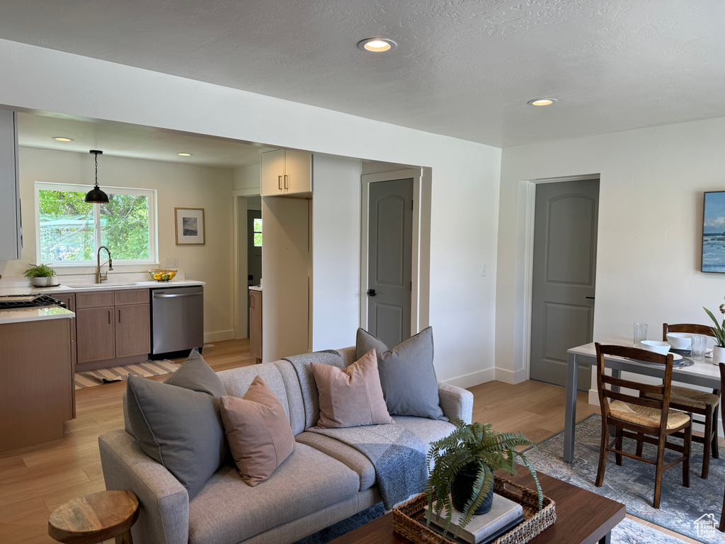 Living area with light wood finished floors, recessed lighting, and baseboards