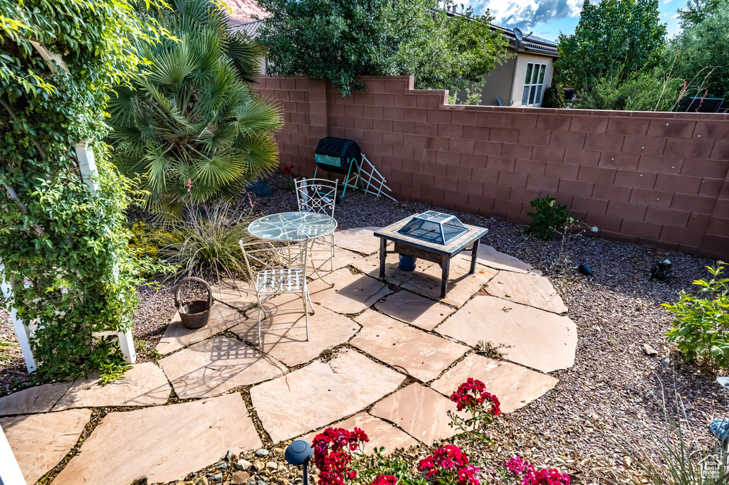 View of patio featuring fence and a grill