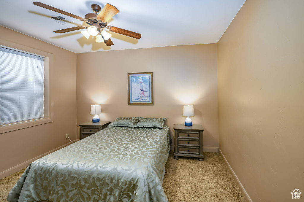 Carpeted bedroom with baseboards and ceiling fan