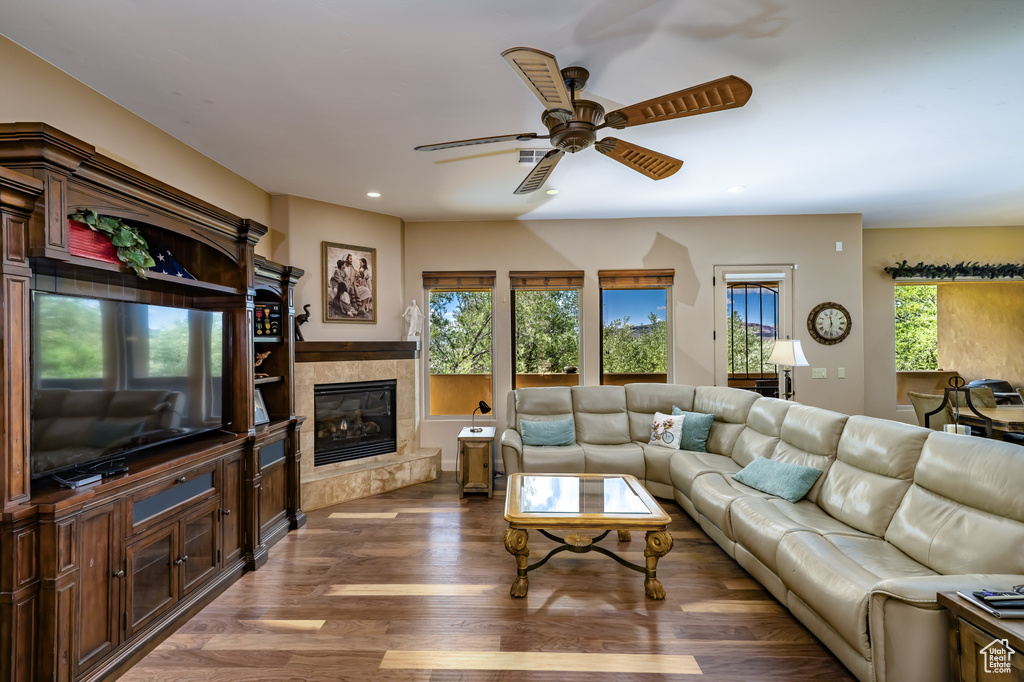 Living area with a ceiling fan, wood finished floors, a tile fireplace, and recessed lighting