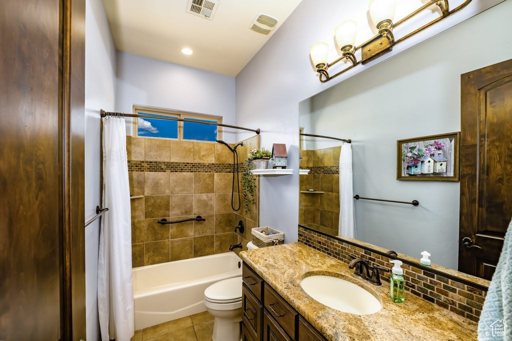 Full bathroom featuring tile patterned floors, toilet, vanity, decorative backsplash, and shower / bath combination with curtain