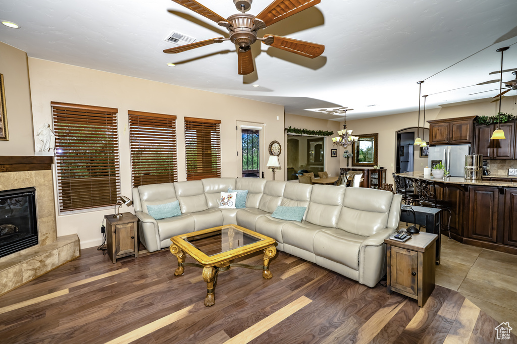 Living room with ceiling fan, a premium fireplace, and wood finished floors