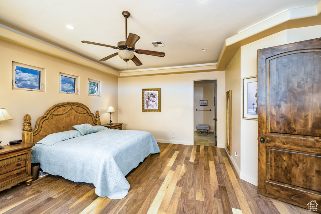 Bedroom with wood finished floors, baseboards, and a ceiling fan