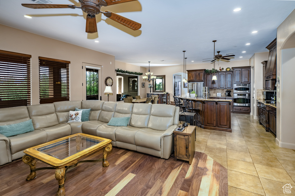 Living room with ceiling fan, recessed lighting, light tile patterned floors, and a chandelier