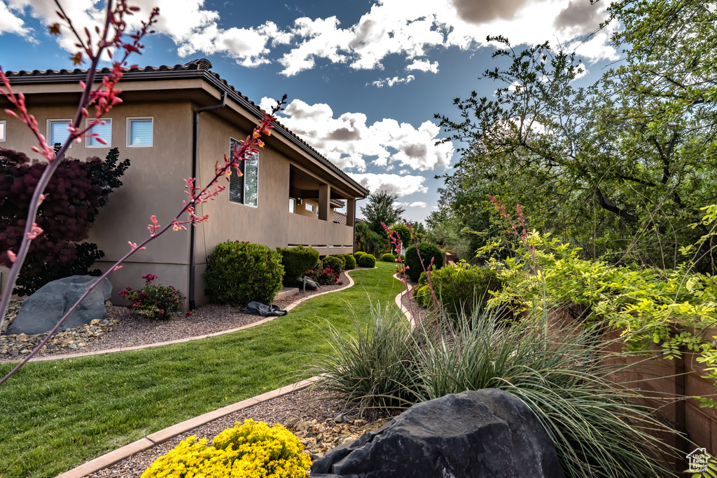 View of property exterior with a yard and stucco siding