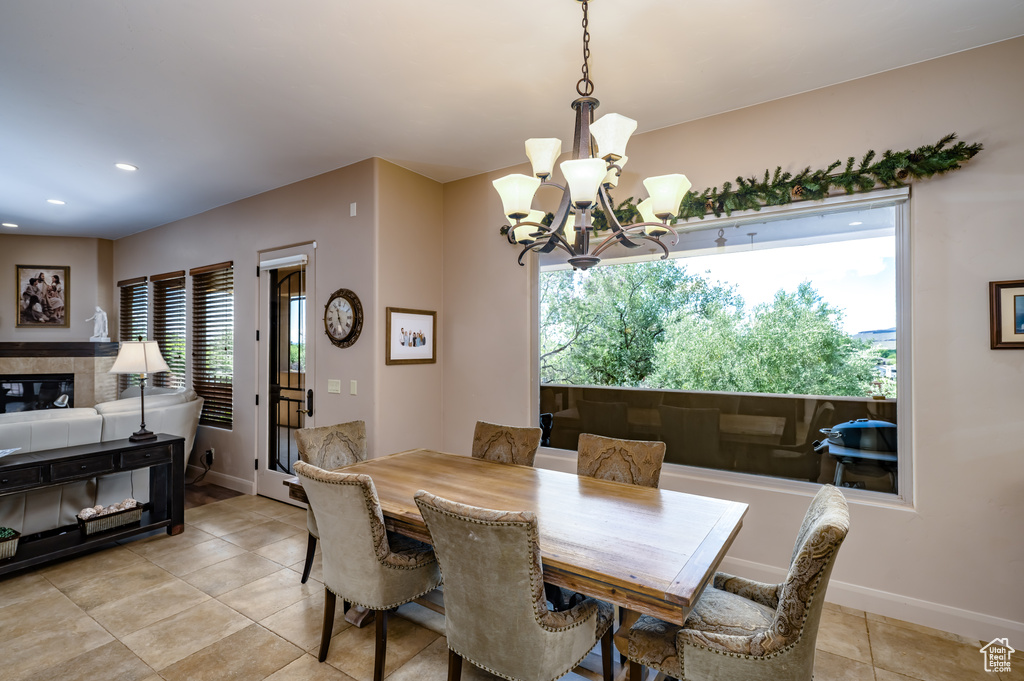Dining area with a chandelier, light tile patterned flooring, baseboards, and recessed lighting