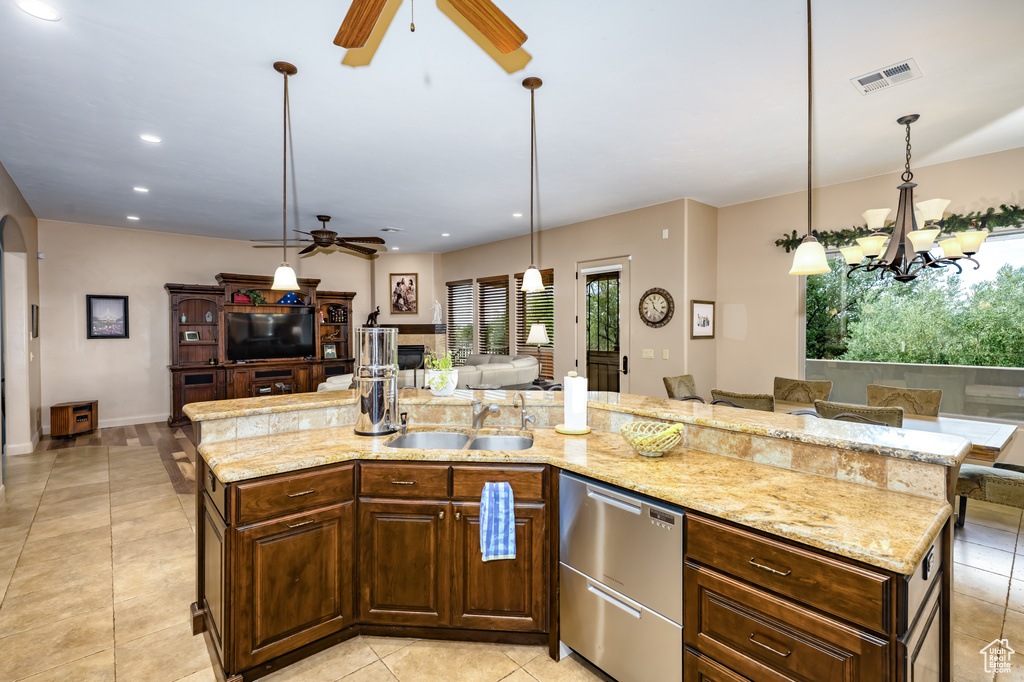 Kitchen with a ceiling fan, a sink, dishwasher, open floor plan, and a chandelier
