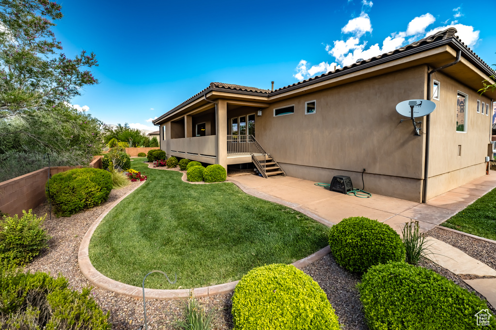 Back of property featuring a lawn and a tile roof