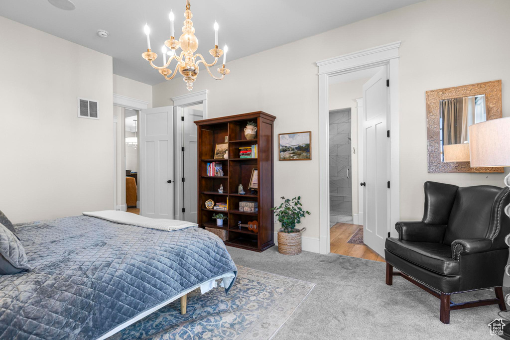 Bedroom with a chandelier, carpet, and ensuite bath
