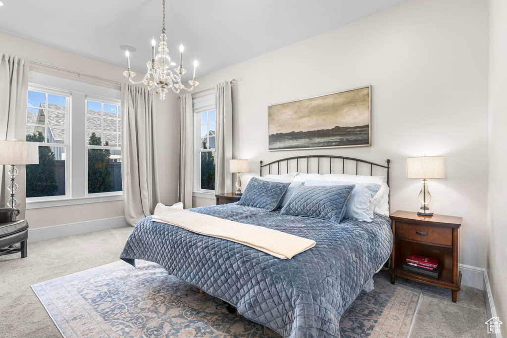 Bedroom with carpet flooring, a chandelier, and baseboards