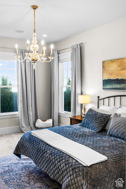 Bedroom with a chandelier, carpet floors, and baseboards