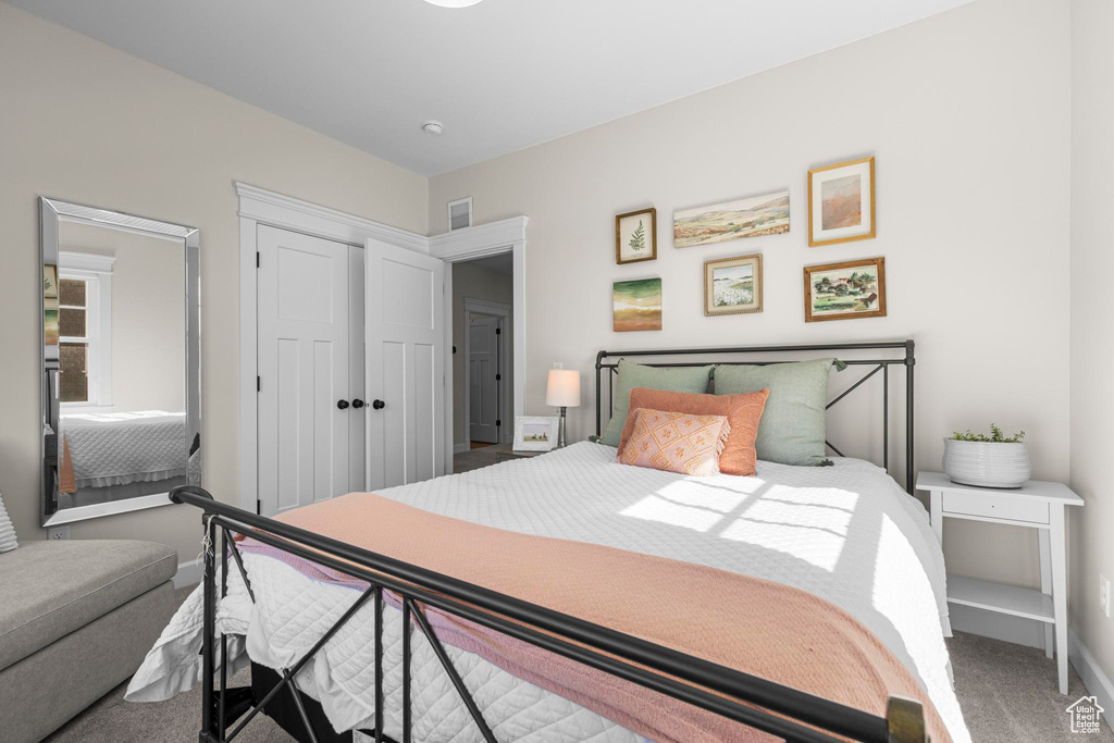 Carpeted bedroom with a closet and baseboards