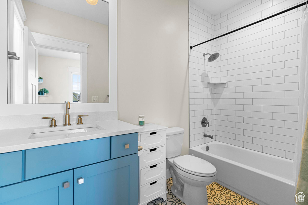 Full bathroom with toilet, vanity, and shower / tub combination
