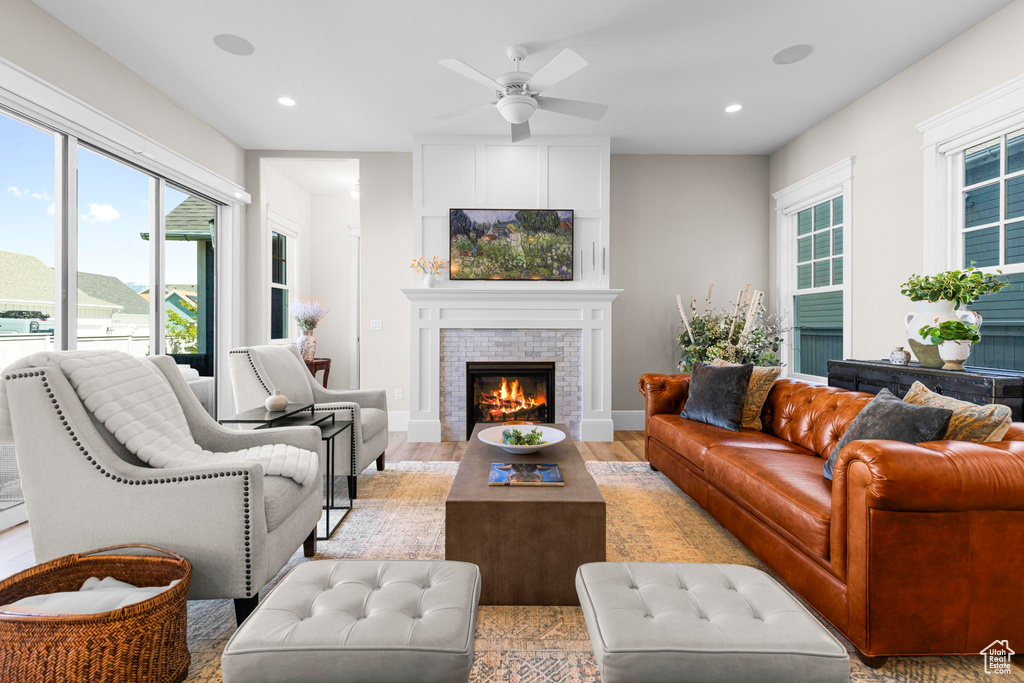 Living area with plenty of natural light, a fireplace, ceiling fan, recessed lighting, and light wood-type flooring