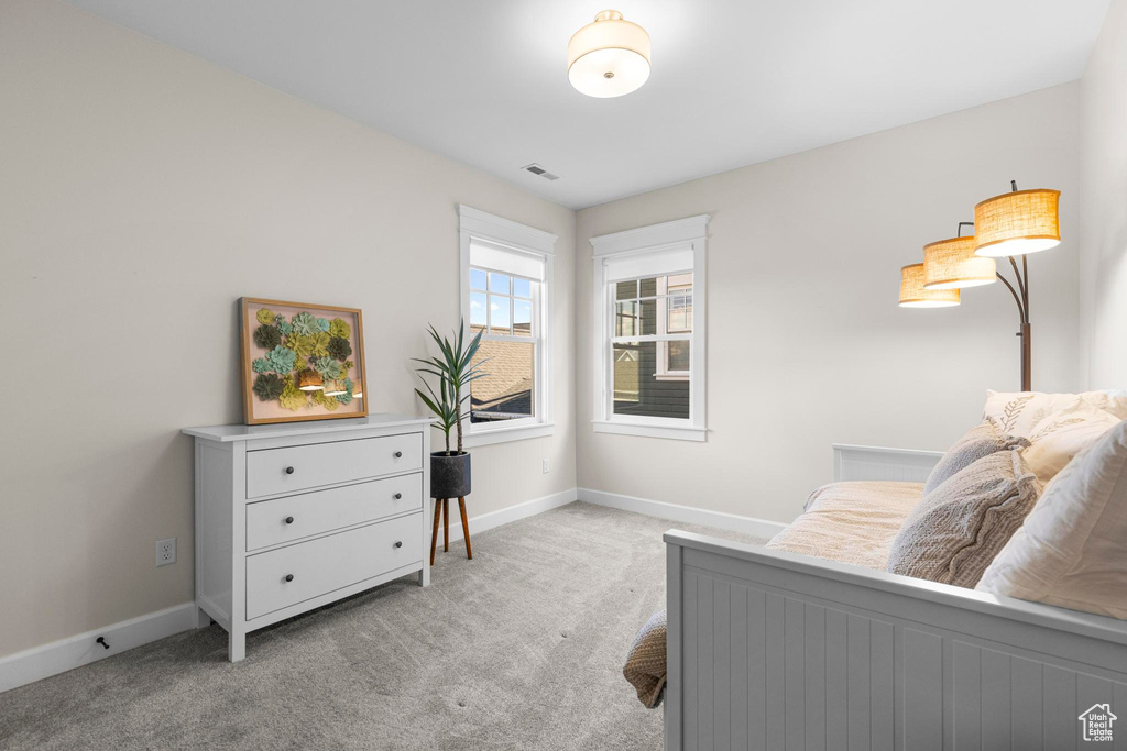 Bedroom featuring light carpet and baseboards