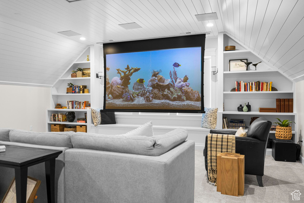 Carpeted home theater with built in features, wooden ceiling, and vaulted ceiling