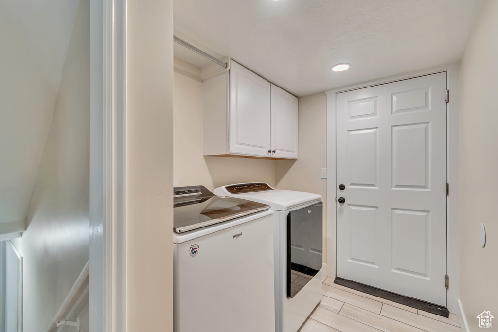 Washroom featuring separate washer and dryer, cabinet space, recessed lighting, and light tile patterned floors