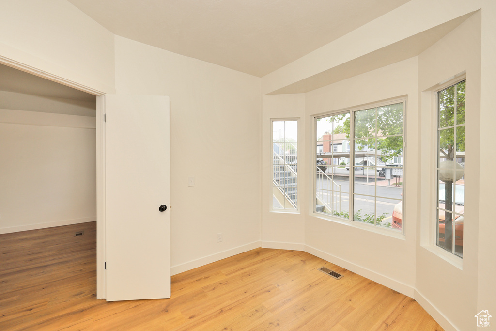 Unfurnished room with light wood finished floors and baseboards