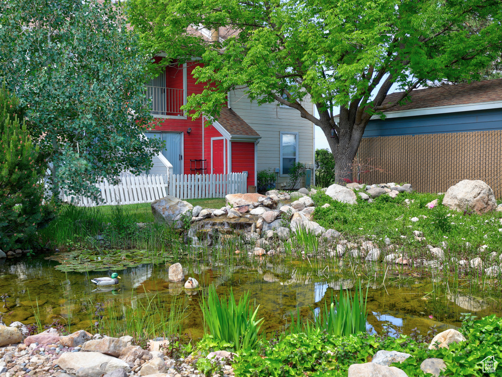 View of yard featuring fence and a small pond