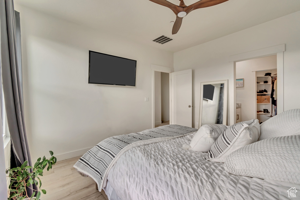 Bedroom with light wood-type flooring, baseboards, and ceiling fan