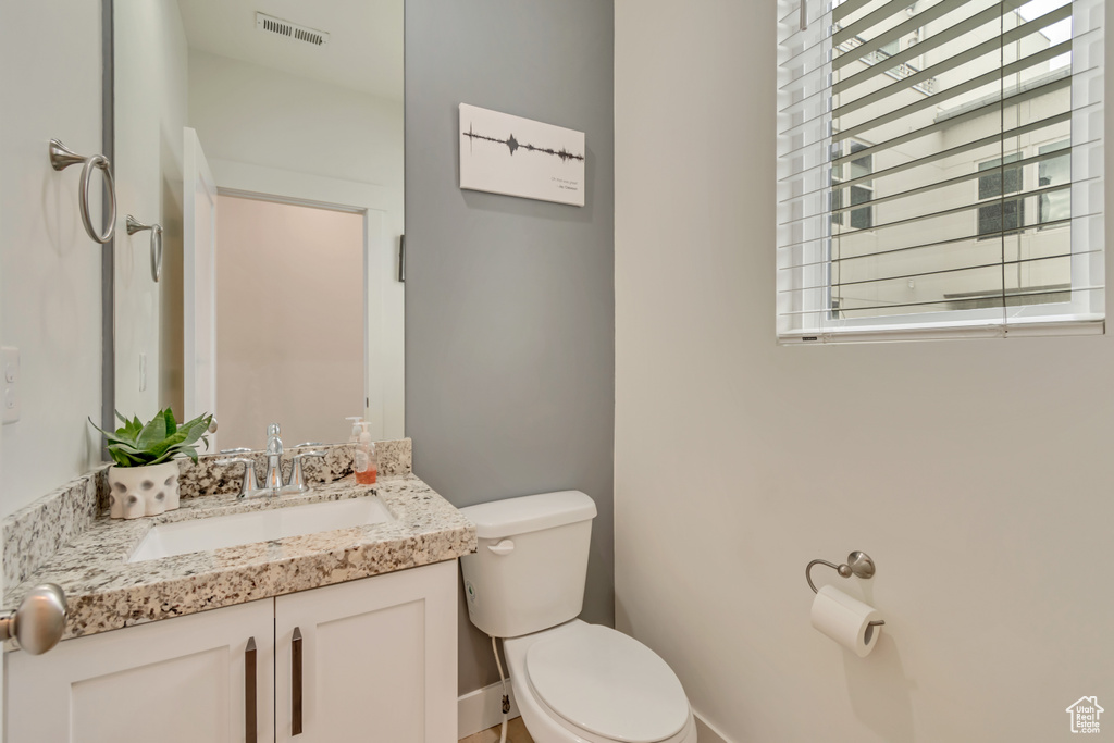 Half bathroom featuring toilet and vanity