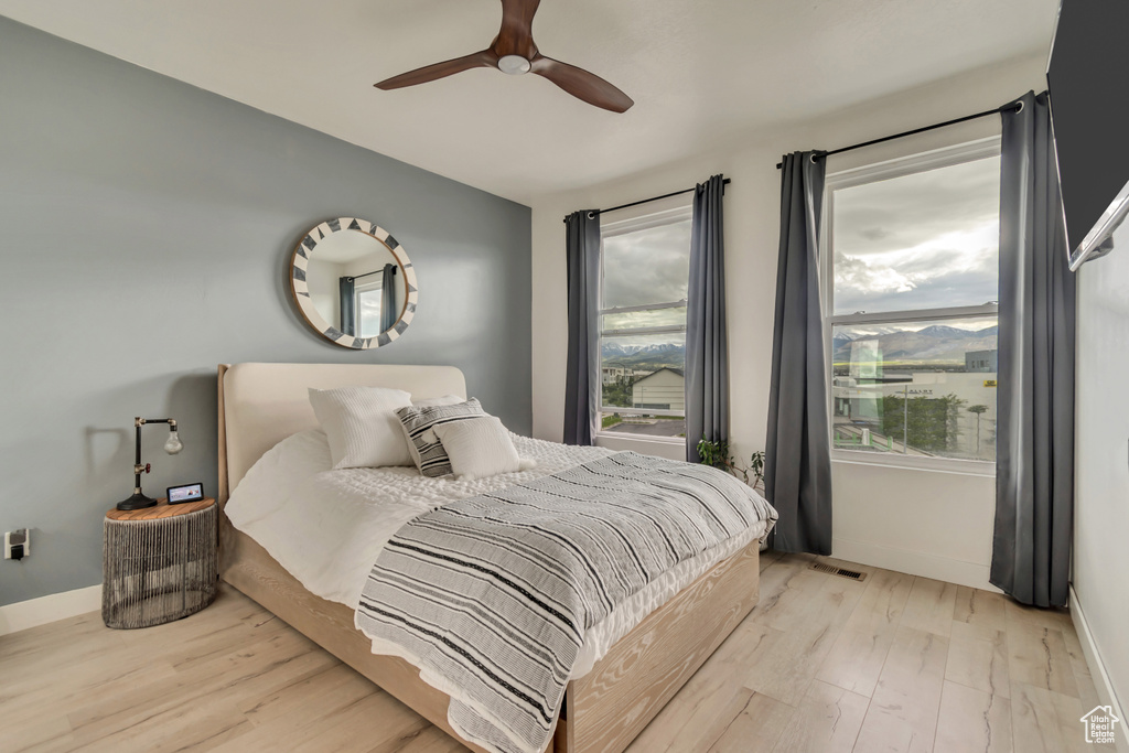 Bedroom with light wood-type flooring, baseboards, and a ceiling fan