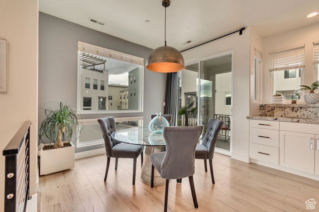 Dining area with light wood-type flooring and recessed lighting