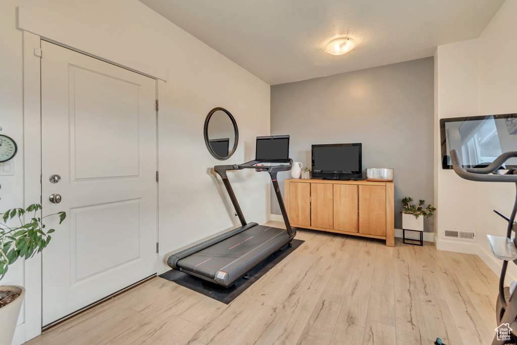 Exercise room featuring light wood-type flooring and baseboards