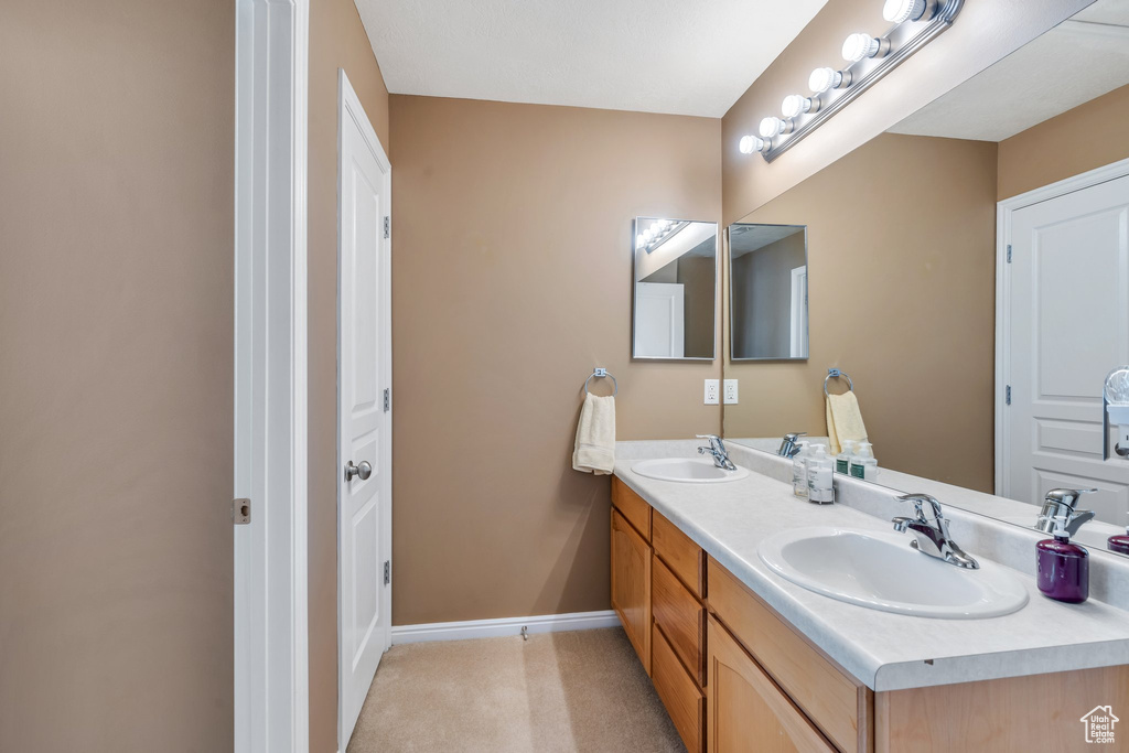 Full bath featuring double vanity and baseboards