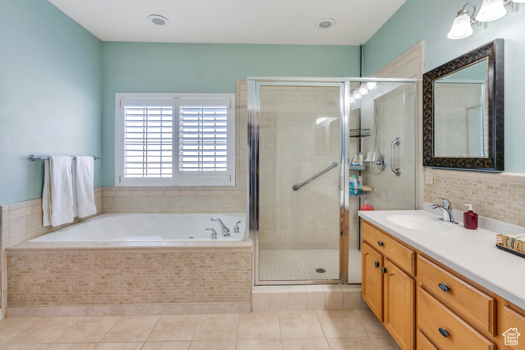 Bathroom with vanity, a stall shower, a bath, and tile patterned flooring