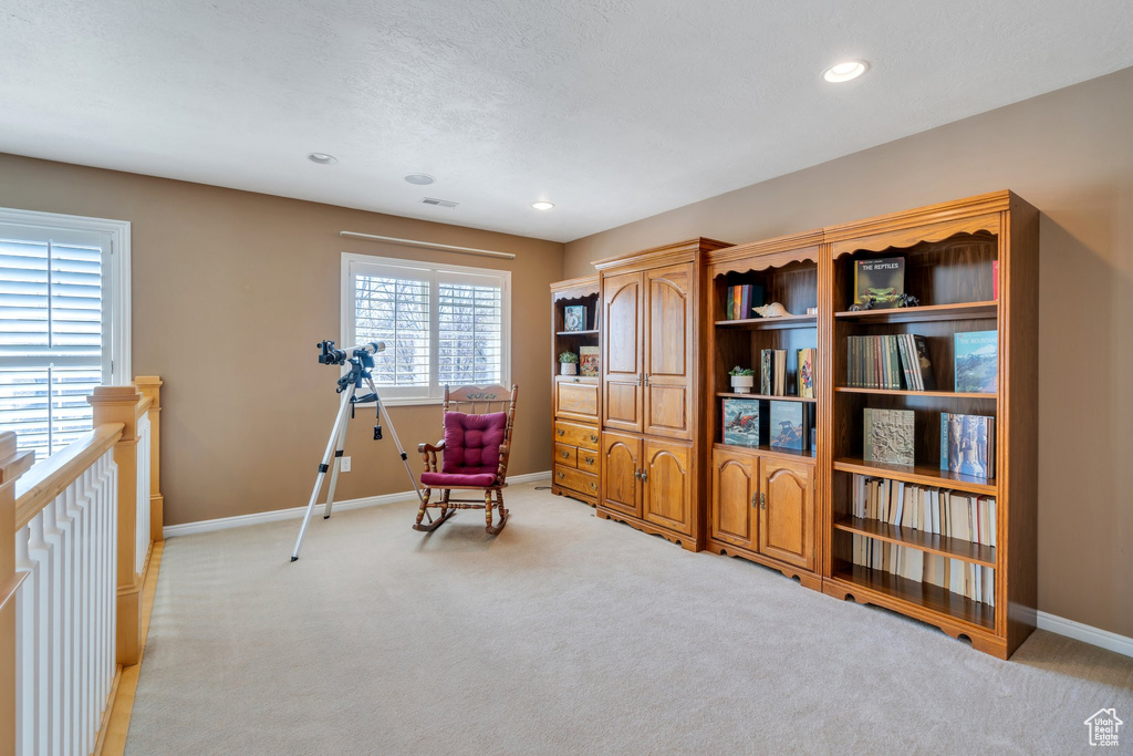 Sitting room with light colored carpet, baseboards, and recessed lighting