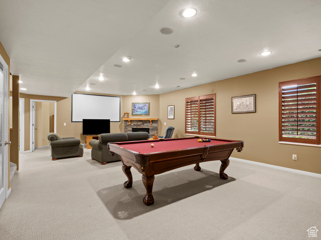 Playroom featuring light colored carpet, billiards table, recessed lighting, baseboards, and a stone fireplace