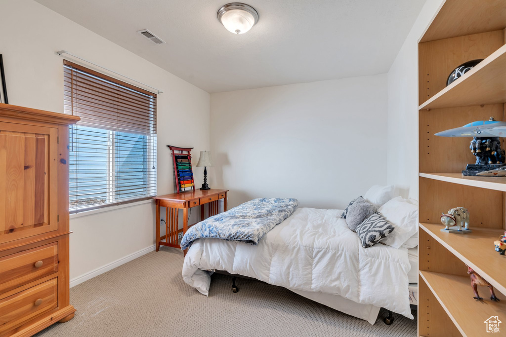 Bedroom featuring light colored carpet and baseboards
