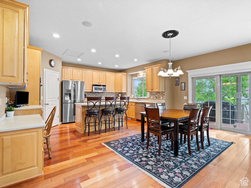 Dining room featuring light wood-style flooring, a chandelier, and recessed lighting