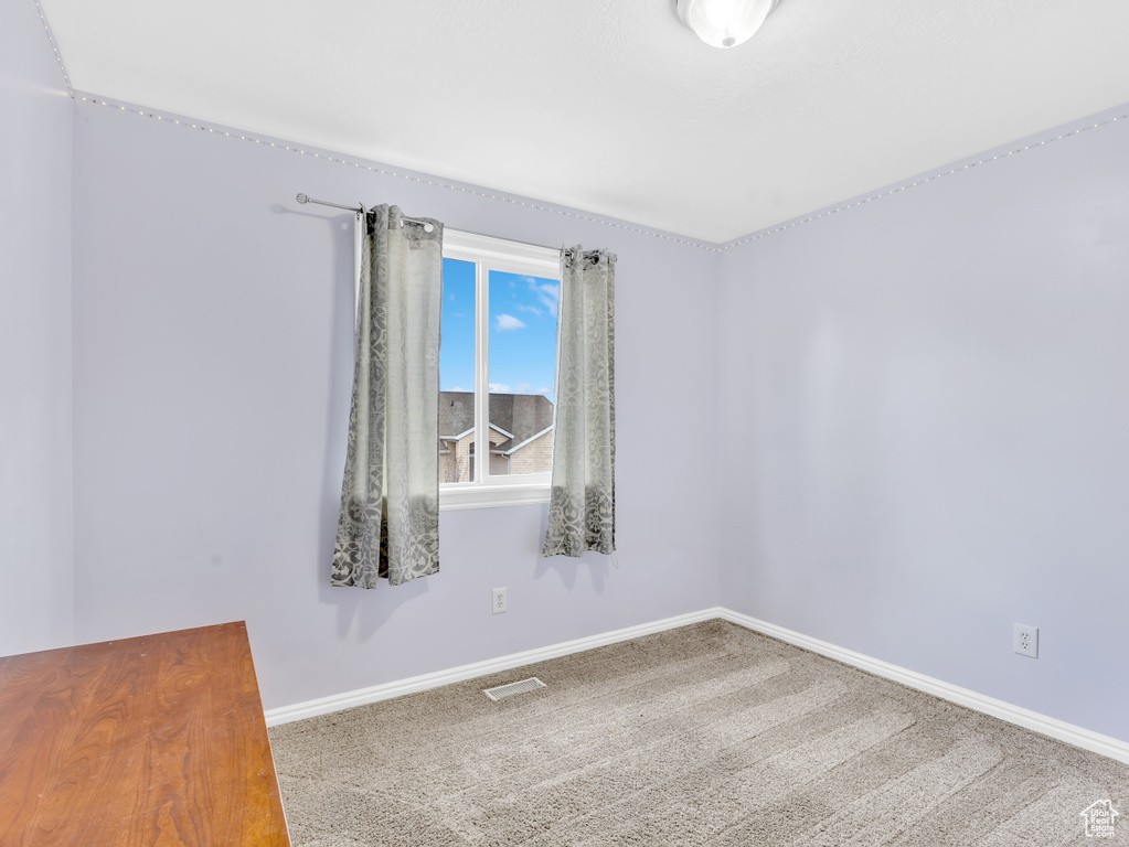 Carpeted empty room featuring baseboards