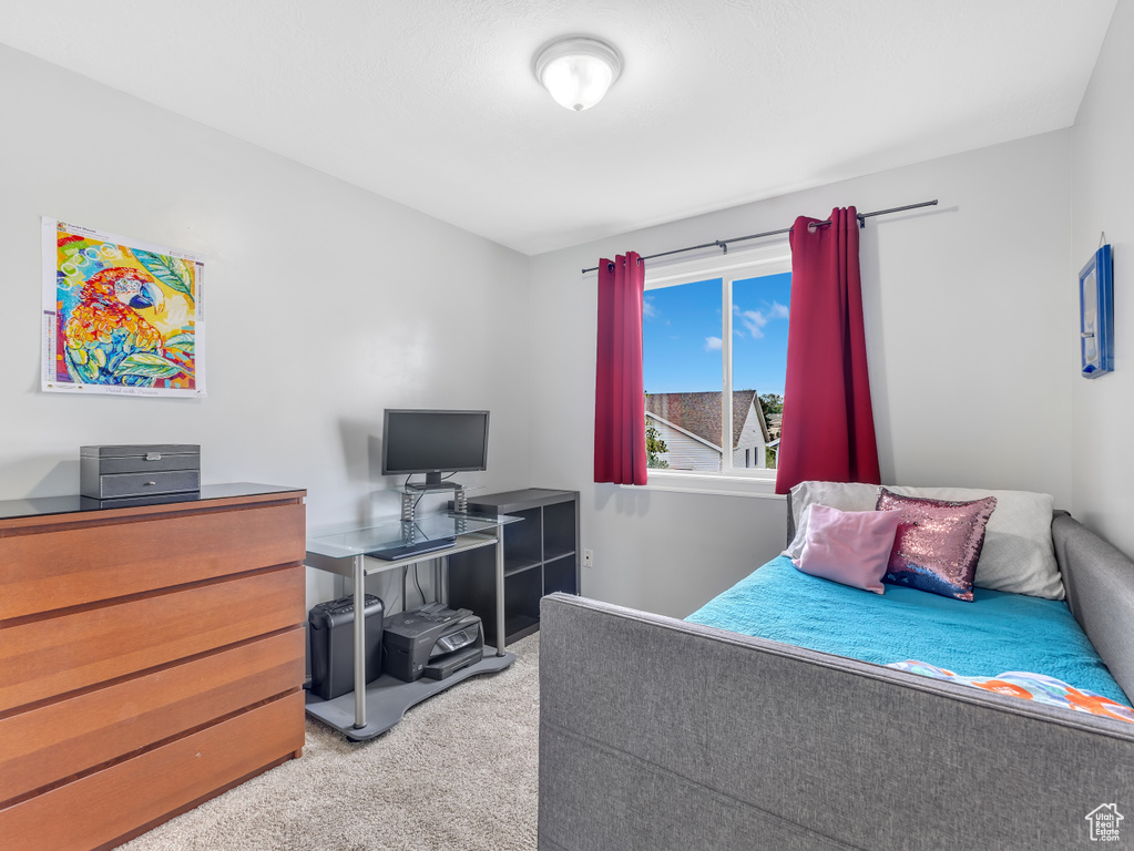 Carpeted bedroom with an office area