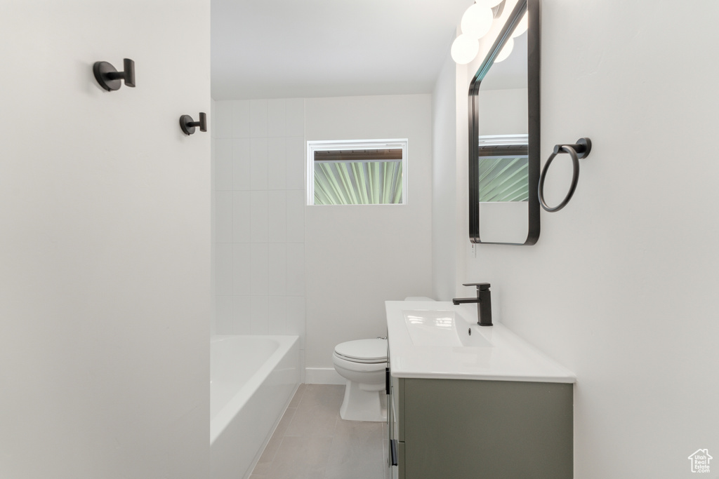 Full bathroom with toilet, vanity, and tile patterned flooring