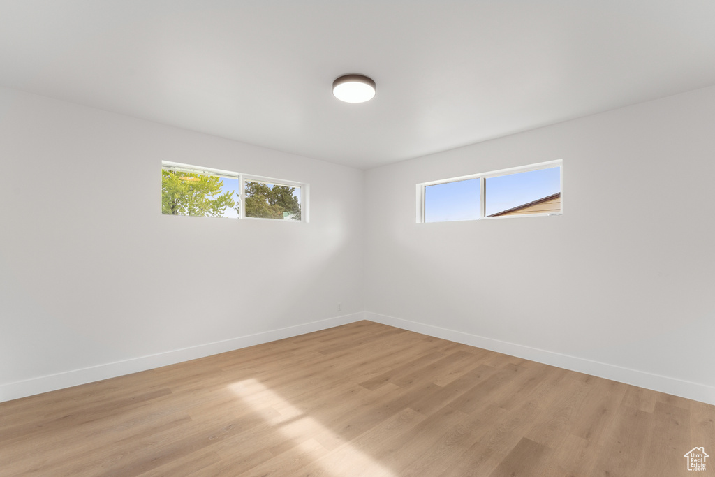 Spare room with baseboards and light wood-type flooring