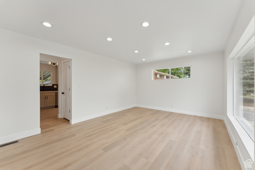 Spare room featuring recessed lighting, light wood-style floors, and baseboards