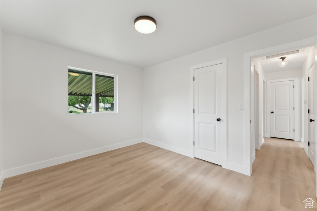 Unfurnished bedroom with baseboards and light wood-style floors