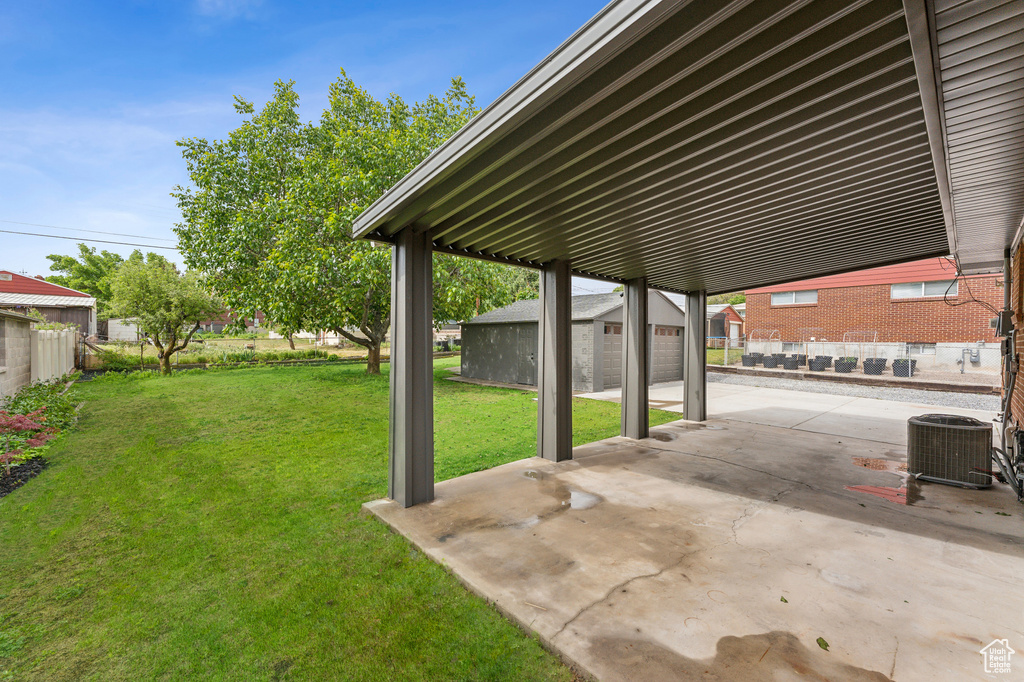 View of yard featuring cooling unit, an outdoor structure, and a patio