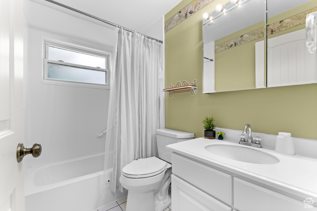 Bathroom featuring toilet, vanity, shower / tub combo with curtain, and tile patterned flooring