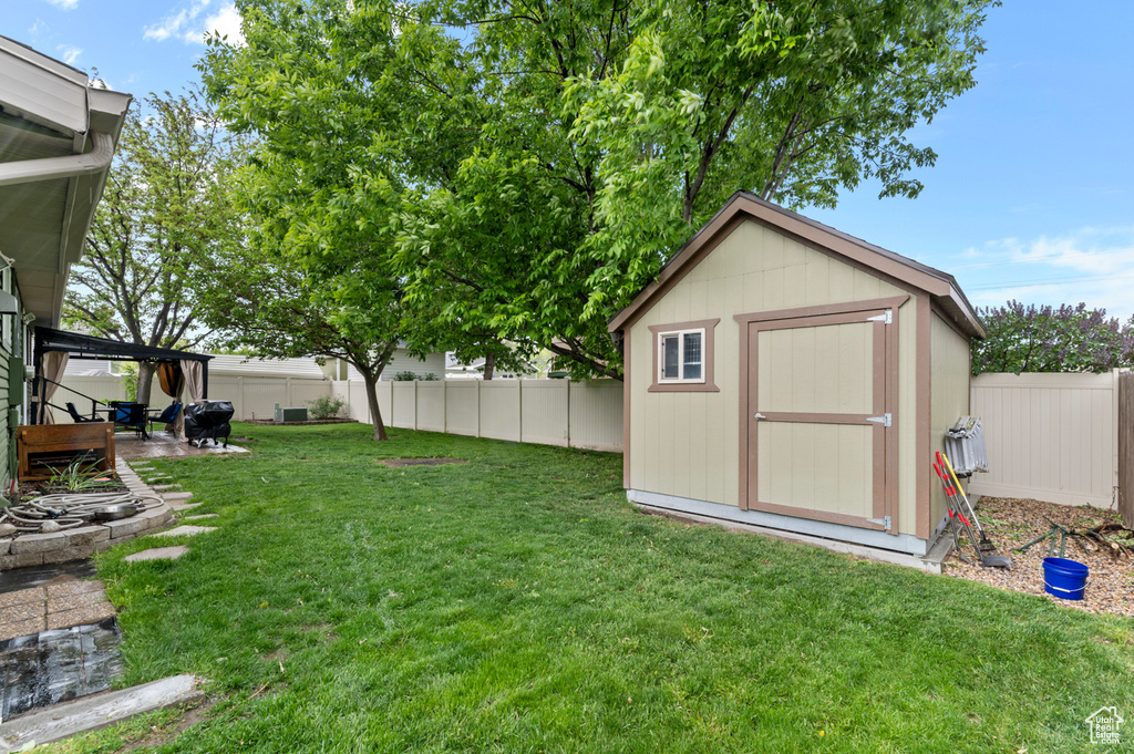 View of yard featuring a storage unit, an outdoor structure, and a patio