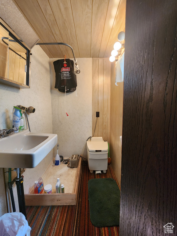 Half bath with wood ceiling, toilet, and a sink