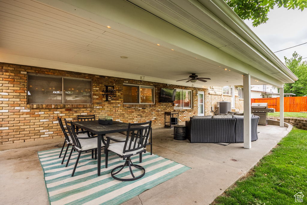View of patio featuring a ceiling fan, grilling area, fence, an outdoor living space, and outdoor dining area
