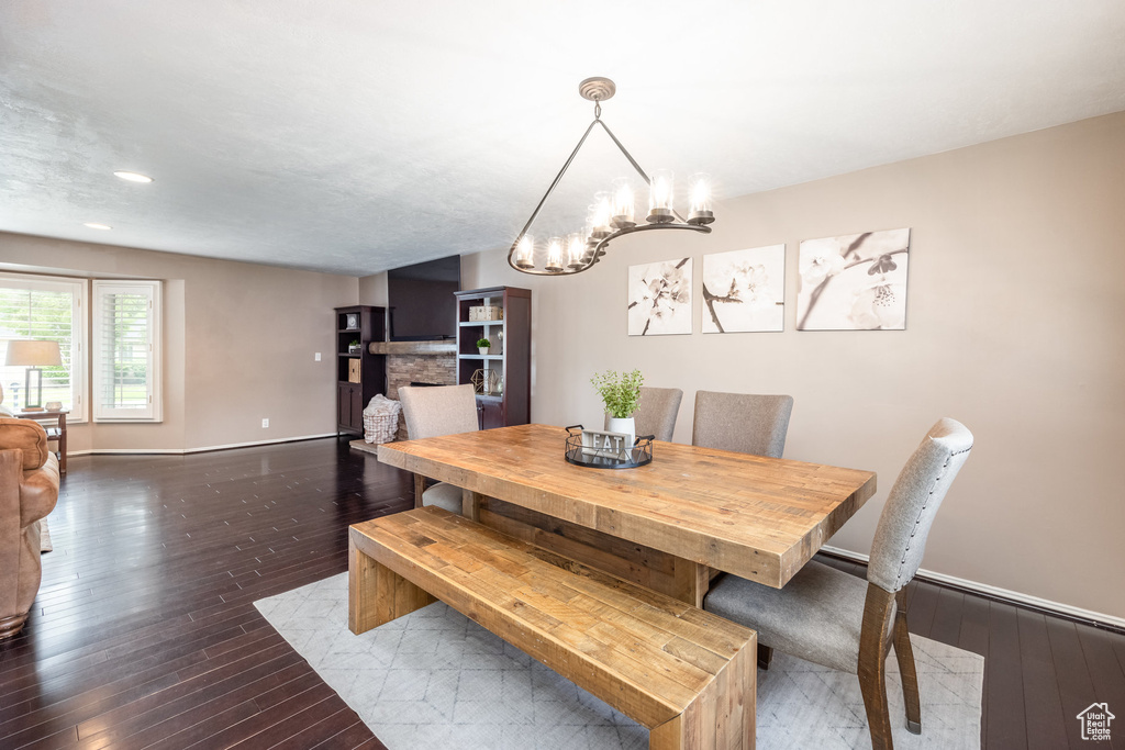 Dining space featuring wood-type flooring, a chandelier, baseboards, and recessed lighting