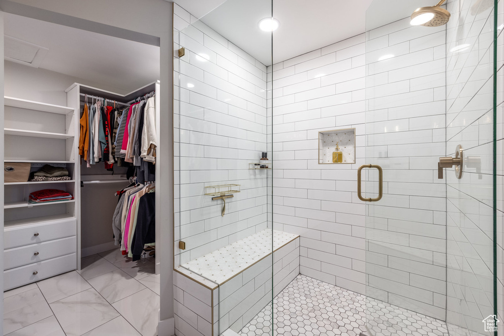 Bathroom with a stall shower and a spacious closet